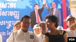 Cambodia National Rescue Party lawmaker Tioulong Saumura talks to Kem Sokha the new president of CNRP during the party's convention on March 2, 2017. (Aun Chhengpor/VOA Khmer) 