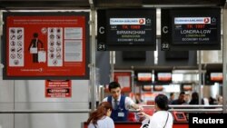 FILE - Passengers check-in for UK bound flights at a Turkish Airlines counter at Ataturk International airport in Istanbul, Turkey, March 24, 2017. 