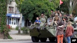 Warga melambai kepada pemberontak pro-Rusia dalam parade di Luhansk, Ukraina timur (foto: dok).