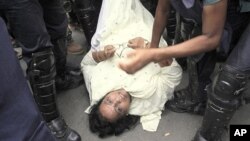 Bangladesh riot police detain an opposition activist, on ground, during a 36-hour strike that began at dawn Sunday in Dhaka, Bangladesh, June 12, 2011