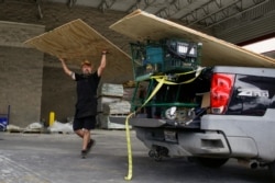 Paul Humphrey, of New Orleans, loads plywood into his truck, to board a friend's home in preparation for the arrival of hurricanes Marco and Laura, at Lowe's in New Orleans, Louisiana, U.S., Aug. 23, 2020.