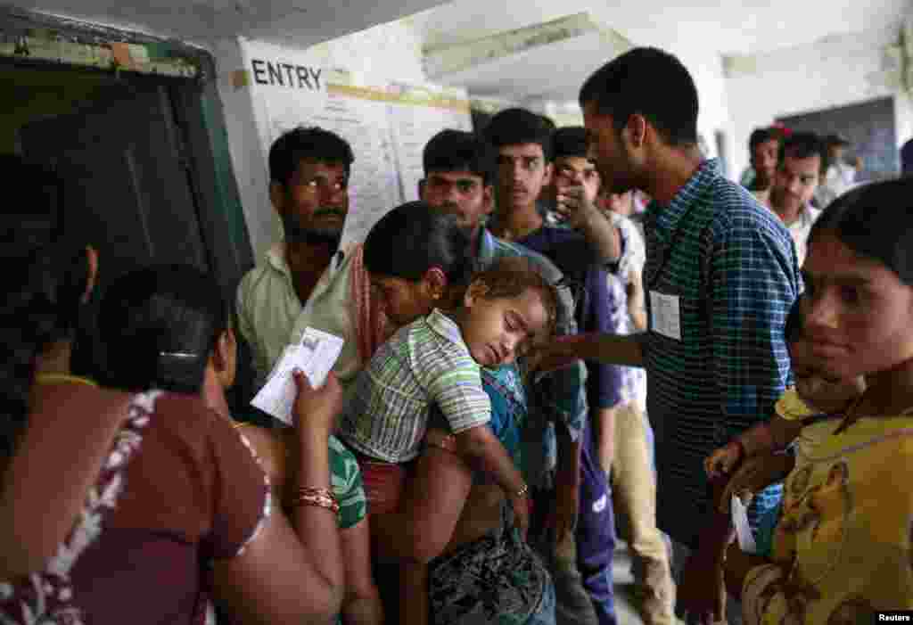 People line up to cast their votes outside a polling station during the seventh phase of India's general election, in Rangareddy district in the southern state of Andhra Pradesh, April 30, 2014.