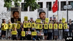 Para aktivis berunjuk rasa atas penahanan ketua lokal Amnesty International divisi Turki Taner Kilic, di depan Kedubes Turki di Berlin, Jerman.