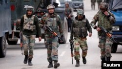 FILE - Indian army soldiers patrol a street near a site of a gunbattle between Indian security forces and suspected militants in Khudwani village of South Kashmir's Kulgam district, April 11, 2018. 