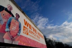 FILE - A sign announcing hiring is displayed in the parking lot of a Home Depot, Feb. 22, 2021, in Cockeysville, Md.