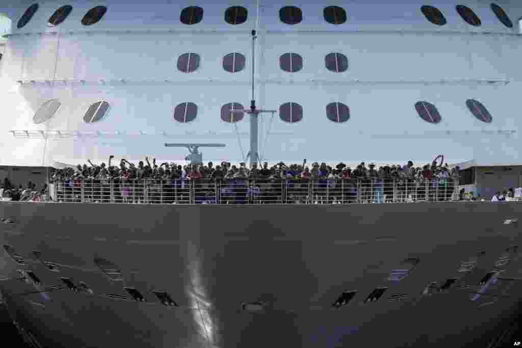 Passengers stand on the forward of the Brilliance of the Seas cruise ship as the vessel approaches the gates of Miraflores Locks to become the first cruiser of the season to pass through the Panama Canal in Panama City.