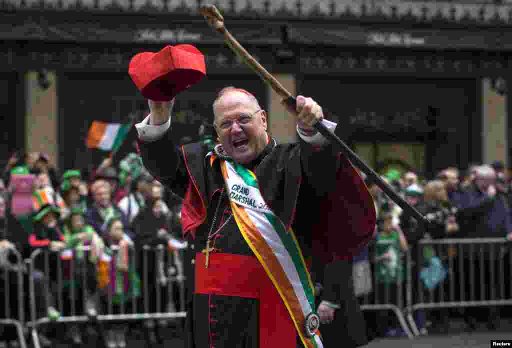 Cardinal Timothy Dolan, Archbishop of the Archdiocese of New York, waves to spectators as he marches as the Grand Marshal of the annual New York City St. Patrick's Day parade up Fifth Avenue in the Manhattan Borough of New York, March 17, 2015. 