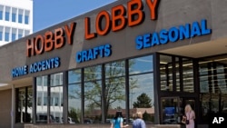 FILE - Customers enter and exit a Hobby Lobby store in Denver. 