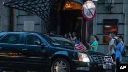 A car bearing the U.S. flag arrives with a convoy at the Peace Hotel in Shanghai on July 30, 2019. 