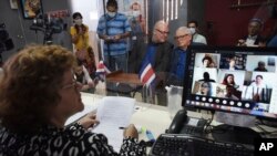 Through video conferencing, invitees attend the matrimony of gay equality activist Marco Castillo, right center, and his longtime partner Rodrigo Campos, in San Jose, Costa Rica, May 26, 2020. 