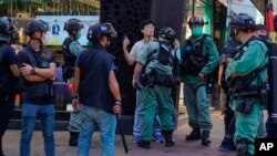 Polisi Hong Kong menahan seorang aktivis pro-demokrasi dalam aksi unjuk rasa hari Minggu (28/6). 