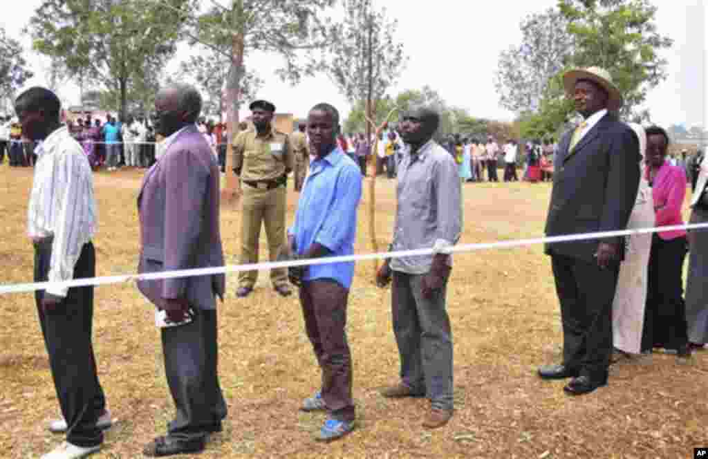 Uganda's President Yoweri Kaguta Museveni, wearing hat at right, stands in a queue as he waits with other voters to place his ballot in Kiruhura district, which is Museveni's home area, at a Polling station about 300 Kms (200 miles) west of Kampala, Ugan