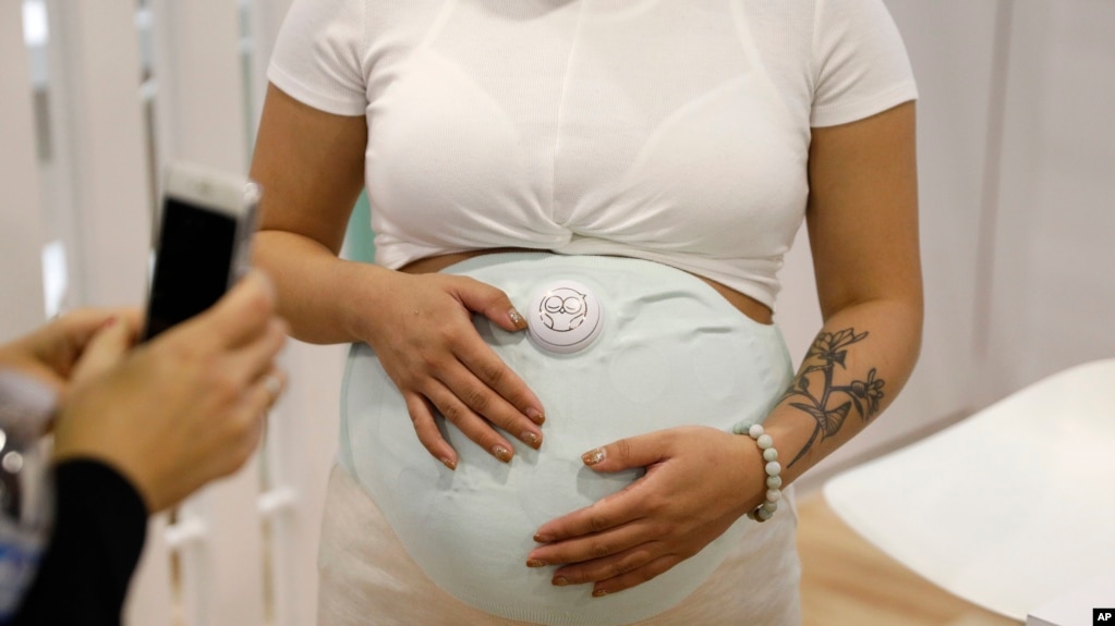 A model wears the Owlet Band pregnancy monitor at the Owlet booth at CES International, Jan. 9, 2019, in Las Vegas. The device can track fetal heart rate, kicks and contractions. 