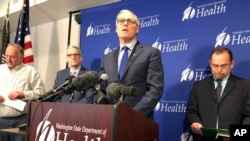 FILE - Washington Gov. Jay Inslee, center, speaks at a news conference in Shoreline, Wash.