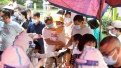 Residents queue to take nucleic acid tests for the coronavirus in Wuhan in China's central Hubei province on August 3, 2021, as the city tests its entire population for Covid-19. (Photo by STR / AFP)