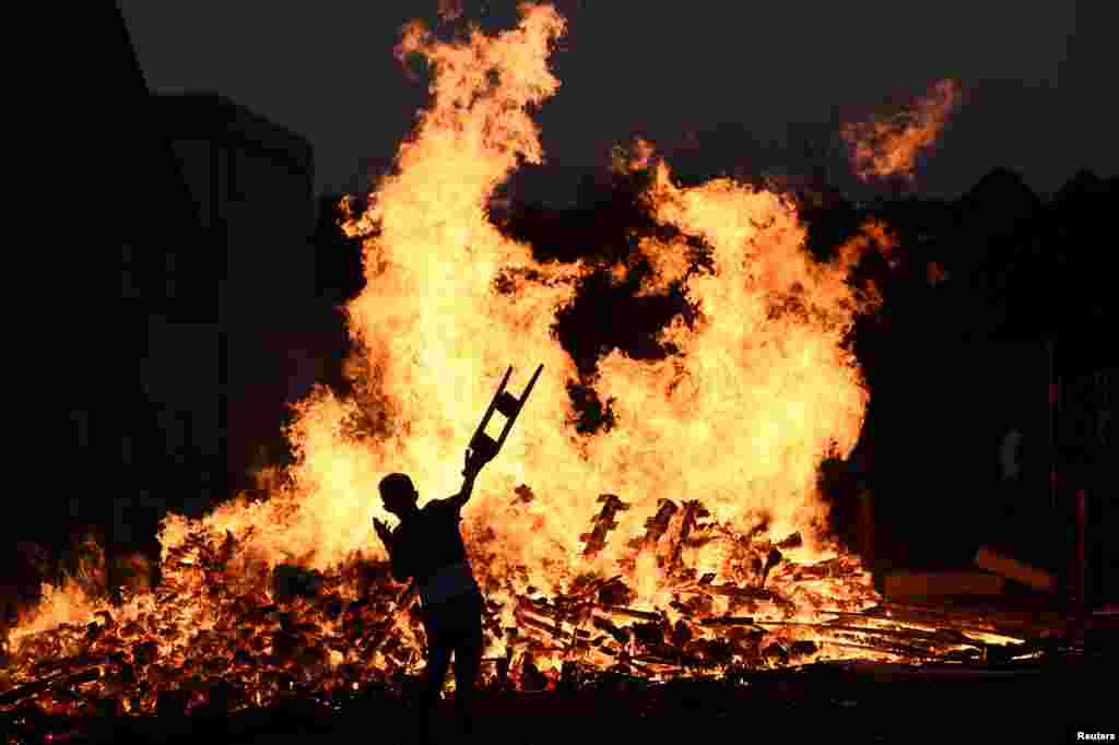 A child throws bits of wood onto a bonfire during the 12th of July celebrations held by members of Loyalist Orders in Belfast, Northern Ireland, July 11, 2017.