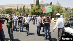 Các nhà báo chờ đợi tại Quảng trường al-Rawda, gần 1 con đường dẫn đến tòa nhà an ninh quốc gia, sau khi lối vào khu vực này bị chặn tại Damascus, 18/7/2012