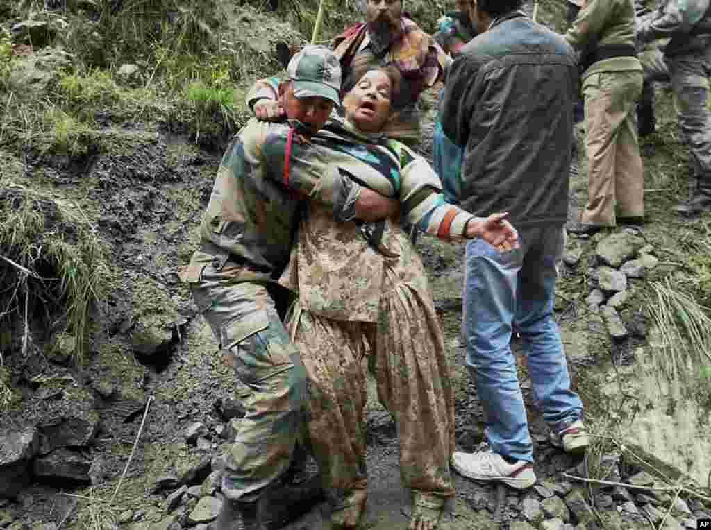 An Indian army personnel carries a stranded woman pilgrim to a safer area in Chamoli district, in the northern Indian state of Uttarakhand, India, June 18, 2013.