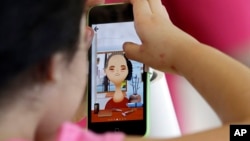 FILE - A young girl plays a game on the new iPhone5c.