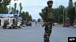 FILE - Security personnel stand guard a street during a lockdown in Srinagar, Aug. 12, 2019. 