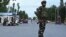 TOPSHOT - Security personnel stand guard a street during a lockdown in Srinagar on August 12, 2019. Indian troops clamped tight restrictions on mosques across Kashmir for Eid al-Adha festival, fearing anti-government protests over the stripping of…