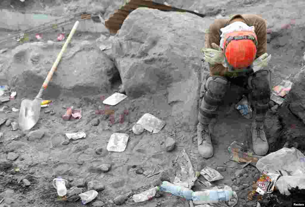 A rescue worker rests an area affected by the eruption of the Fuego volcano at San Miguel Los Lotes in Escuintla, Guatemala, June 10, 2018.