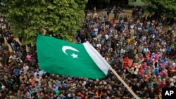 Warga Kashmir mengibarkan bendera Pakistan saat pemakaman Fayaz Ahamed di Kaimuh, 67 km selatan Srinagar, Minggu, 7 Mei 2017. Ahamed tewas Sabtu malam saat para pemberontak menyerang pasukan polisi.