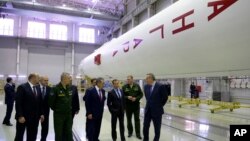 FILE - Russian Prime Minister Dmitry Medvedev (3rd-R) visits an assembly shop, with Angara booster rocket at right, at the Plesetsk Cosmodrome in Plesetsk, northwestern Russia.