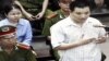 FILE - Nguyen Van Dai, right, testifies in this May 2013 file photo, originally taken from TV footage. The well-known Vietnamese human rights lawyer was arrested Wednesday on anti-state "propaganda" charges.