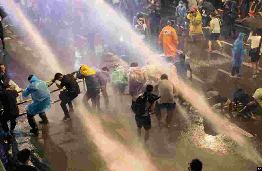 Pro democracy demonstrators face water canons as police try to disperse them from their protest venue in Bangkok, Thailand, Friday, Oct. 16, 2020. Thailand prime minister has rejected calls for his resignation as his government steps up efforts to stop st