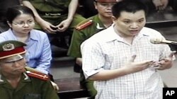 FILE - Nguyen Van Dai, right, testifies in this May 2013 file photo, originally taken from TV footage. The well-known Vietnamese human rights lawyer was arrested Wednesday on anti-state "propaganda" charges.