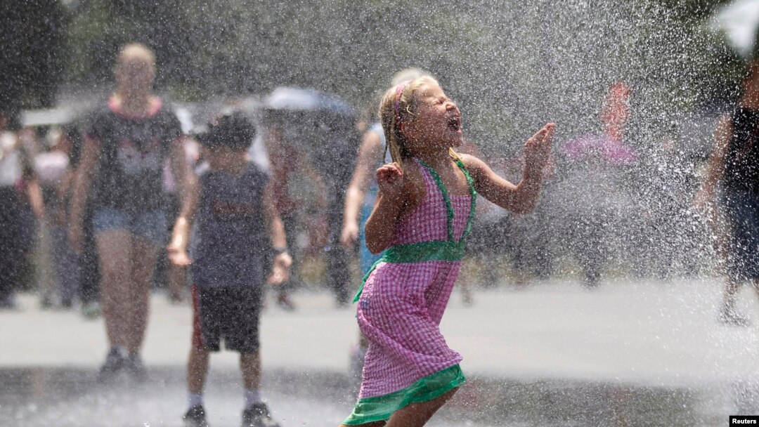 Seorang gadis cilik berlari di tengah percikan air dari selang di depan sebuah memorial di Washington, D.C., saat temperatur di ibukota mencapai lebih dari 38 derajat Celcius (foto: dok).