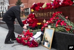 A man lays flowers in memory of victims killed by a bomb blast in a subway train in St. Petersburg, at the memorial stone with the word Leningrad (St. Petersburg) at the Tomb of Unknown Soldier, in front of the Kremlin wall in Moscow, April 4, 2017.