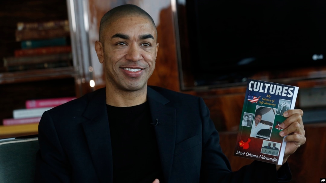 Mark Obama Ndesanjo,adik tiri Presiden AS Barack Obama, memegang bukunya “Cultures: My Odyssey of Self-Discovery” dalam sebuah wawancara di Hong Kong (17/12). (AP/Kin Cheung)