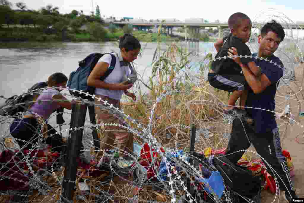 Migrants from Venezuela make their way through the razor wire after crossing the Rio Grande into the United States in Eagle Pass, Texas, Sept. 26, 2023.&nbsp;