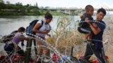 Migranti iz Venecuele probijaju se kroz bodljivkavu žicu nakon što su preko rijeke Rio Grande ušli u Sjedinjene Države, u Igl Pasu, 26. septembra 2023.