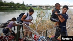 Migranti iz Venecuele probijaju se kroz bodljivkavu žicu nakon što su preko rijeke Rio Grande ušli u Sjedinjene Države, u Igl Pasu, 26. septembra 2023.