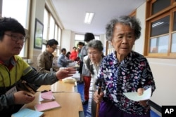 FILE - Elderly women wait to cast their ballots in local elections at a polling station in Nonsan, South Korea, June 4, 2014. In South Korea, 100 working-age people fund the social benefits for 37 citizens.