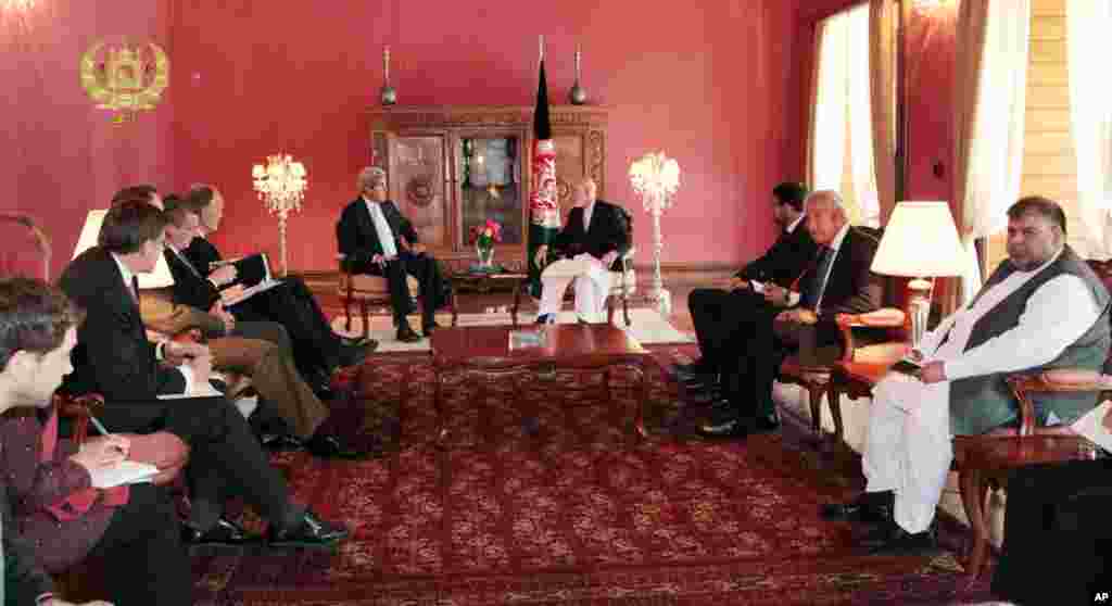 This image released by the Afghan presidential palace shows U.S. Secretary of State John Kerry talking with Afghanistan's President Hamid Karzai at the presidential palace in Kabul, July 11, 2014. 