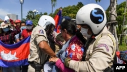 FILE - Local security personnel guards confiscate a loudspeaker from a protester during a protest to mark the 29th annniversary of the Paris Peace Accord in front of the US embassy in Phnom Penh on October 23, 2020. (AFP)