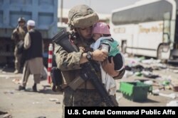 A U.S. Marine carries a baby during an evacuation at Hamid Karzai International Airport, in Kabul, Afghanistan, Aug. 28. (US Marine Corps photo)