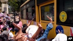 A crowd greets people aboard a bus as it leaves Insein Prison, in Yangon, Myanmar, April 17, 2021.