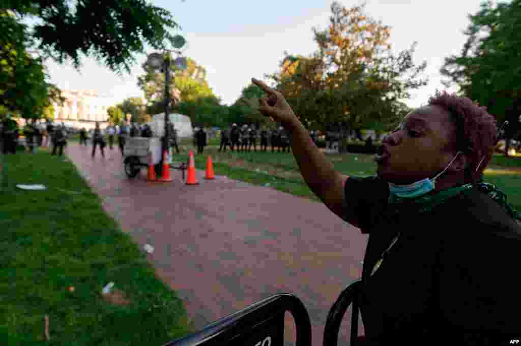 A protestor shouts at a line of policemen as she and hundreds of others protest the death of George Floyd next to the White House on May 31, 2020, in Washington, D.C.