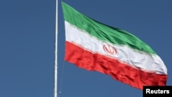 FILE - The Iranian flag is seen flying over a street in Tehran.