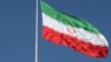 FILE - The Iranian flag is seen flying over a street in Tehran.