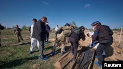 烏克蘭東部頓涅茨克州州長帕夫洛∙基裡連科透露，在烏軍最近剛剛從俄軍手中奪回的利曼市發現了一個大型亂葬崗。圖為法醫和烏克蘭政府官員在亂葬崗現場進行勘察。