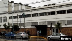 People stand outside the Unionpel paper factory in La Matanza, on the outskirts of Buenos Aires, Argentina, Nov. 19, 2015. 