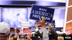 A covention delegate holds a "Make America First Again" sign at the Republican National Convention, July 20, 2016. (A. Shaker/VOA)