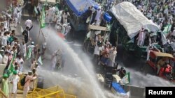 Police use water cannons to disperse farmers during a protest demanding better price for their produce on the outskirts of New Delhi, India, Oct. 2, 2018. 
