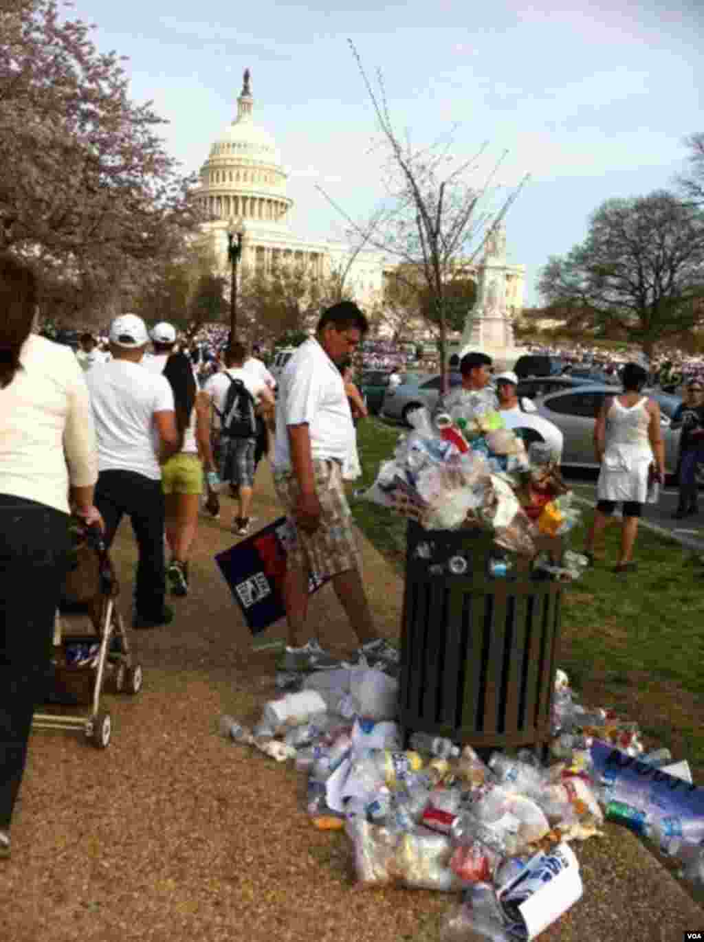 Water bottles and campaign posters litter the ground around a trash can at the pro-immigration rally on Capital Hill. (Photo by Carolyn Presutti)